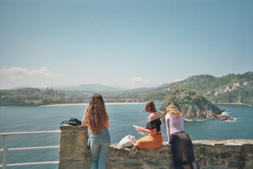 Group of friends staring at the sea in San Sebastian, north of Spain