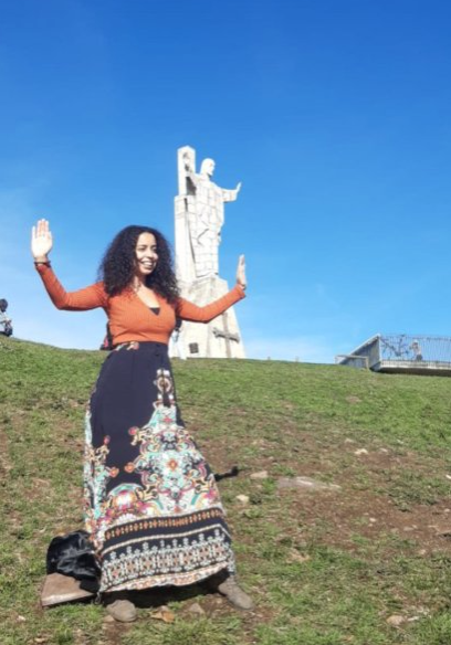 Girl dancing with a big Jesus at her back in the Naranco Mountain in Asturias Spain