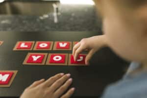 Child playing with letters, spelling out "Love you".
