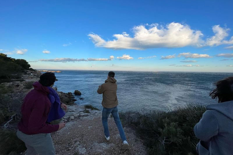 Max with his friends watching the sunset from the coast