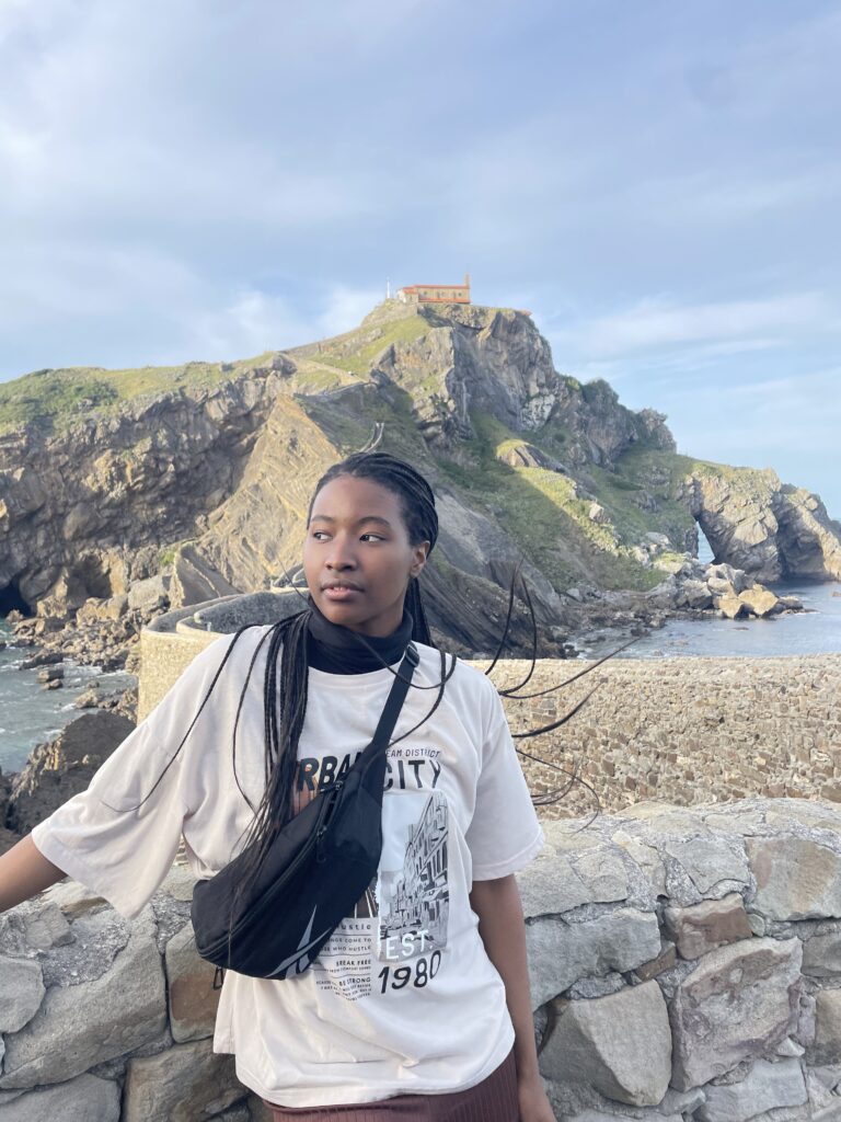 Athi posing in front of an ocean view. Teach English abroad.